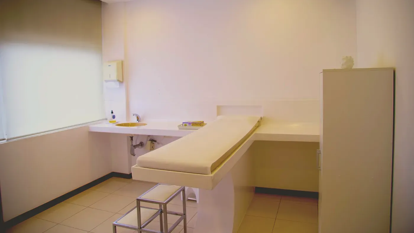Tomt undersökningsrum på en hudklinik med brits och handfat