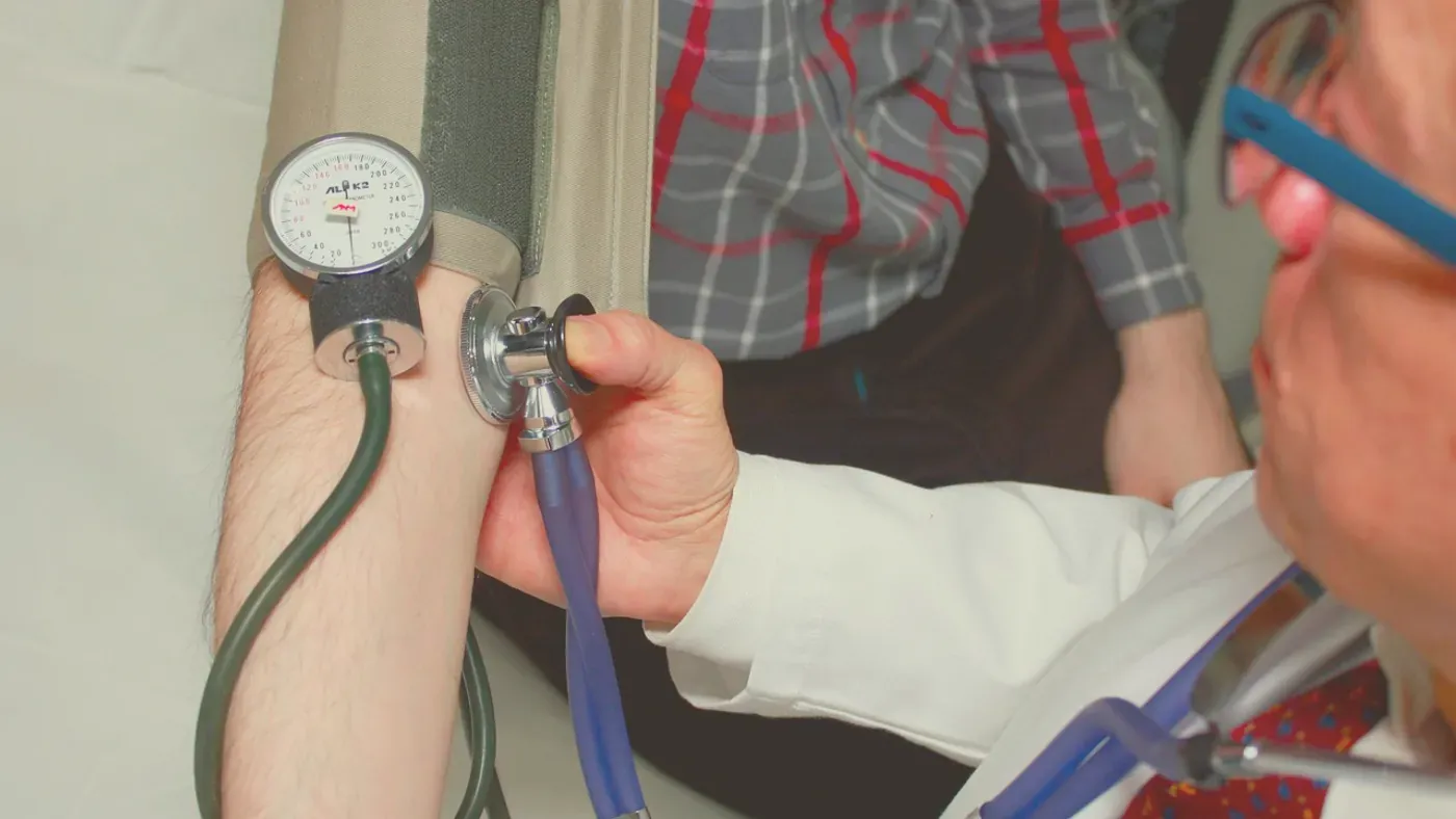 Läkare kontrollerar blodtrycket på en patient inför hälsobedömning