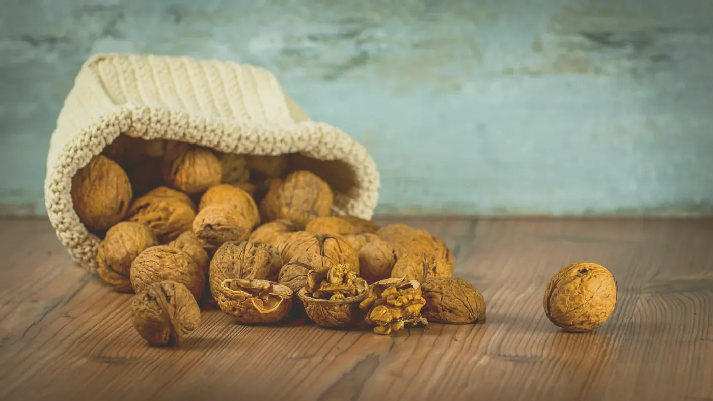 Valnötter i en trästäva, ett av matens naturliga källor till biotin